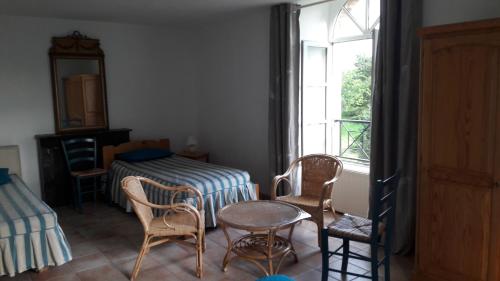Zimmer mit einem Tisch, Stühlen und einem Fenster in der Unterkunft Gîte Le Moulin de la Chaussee in Saint-Denis-dʼOrques