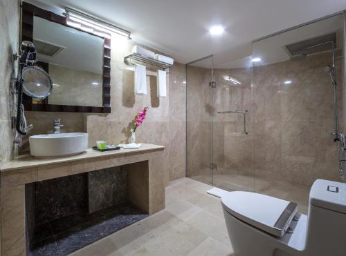 a bathroom with a toilet and a sink and a shower at Grand Palace Hotel & Resorts Rangpur in Rangpur