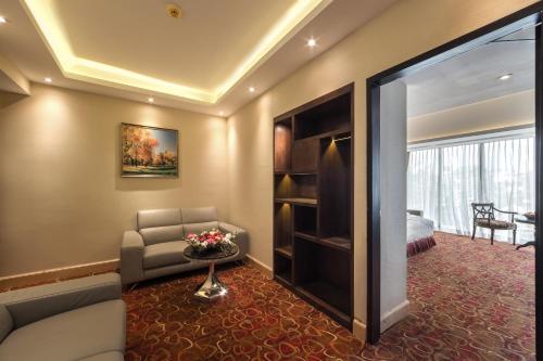 a living room with a couch and a chair at Grand Palace Hotel & Resorts Rangpur in Rangpur