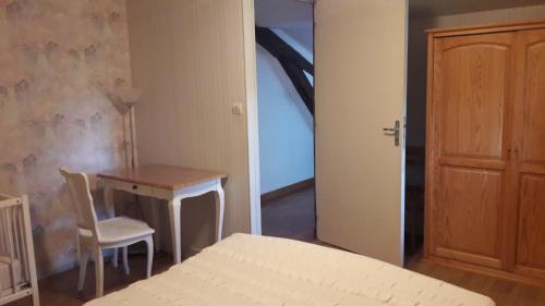 a bedroom with a bed and a table and a chair at Gîte Le Moulin de la Chaussee in Saint-Denis-dʼOrques