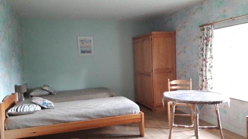 a bedroom with a bed and a table and a chair at Gîte Le Moulin de la Chaussee in Saint-Denis-dʼOrques