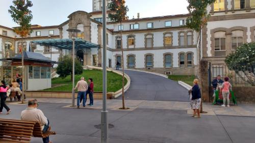 a group of people sitting on a bench in front of a building at Apt Moderno céntrico y soleado in Pontevedra