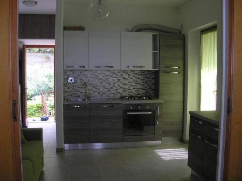 a kitchen with white cabinets and a stove at Residence I Pini in Capoliveri