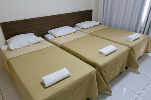 a group of three beds in a room at Velit Hotel in Teresina