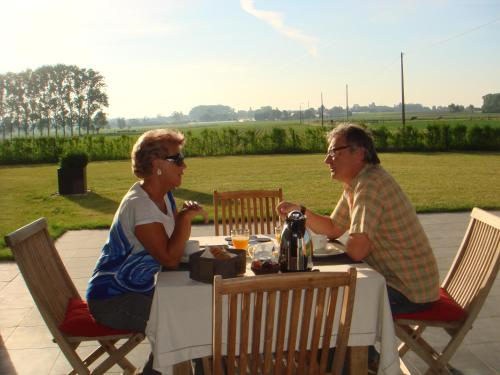 zwei Frauen sitzen an einem Tisch und essen Essen in der Unterkunft B&B Kanegem Onverbloemd in Tielt