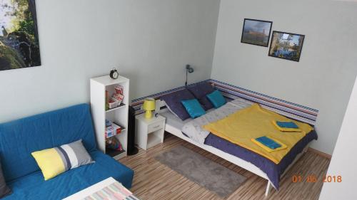 ザトルにあるApartament Kotewka 3のベッドルーム(ベッド1台、青いソファ付)