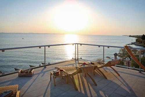 a balcony with chairs and a view of the ocean at Hotel Delfin in Zadar