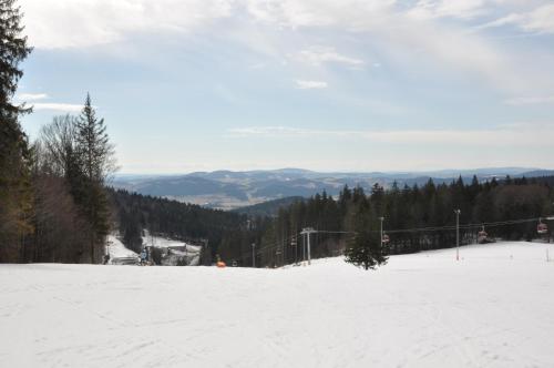 a snow covered slope with a ski lift in the distance at Apartmán Šestka in Nová Pec