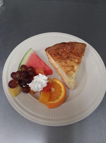 un piatto bianco con un panino, frutta e panna montata di LandMark Inn at the Historic Bank of Oberlin a Oberlin