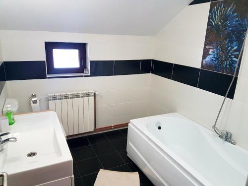a bathroom with a white tub and a sink at Casa David Comarnic in Comarnic