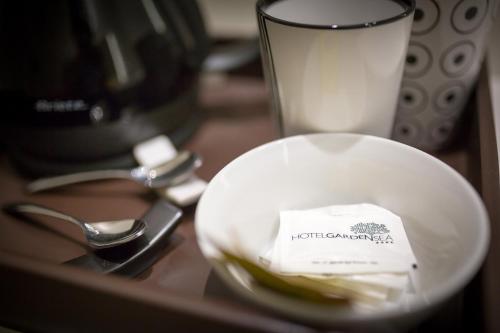 a plate with a piece of paper on a table with a coffee maker at Hotel Garden Sea Wellness & Spa 4 stelle superior in Caorle