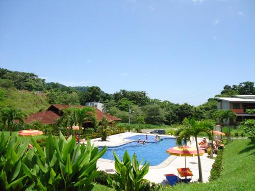 a pool at a resort with people in it at Punta Leona Beach Condos in Jacó