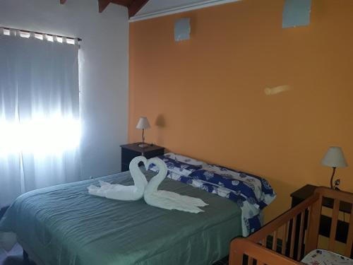 two swans sitting on a bed in a bedroom at Brisa de los Molles in Los Molles