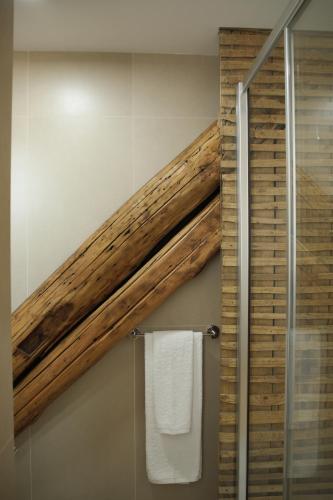 a bathroom with a wooden beam on the wall at Original Douro Hotel in Peso da Régua