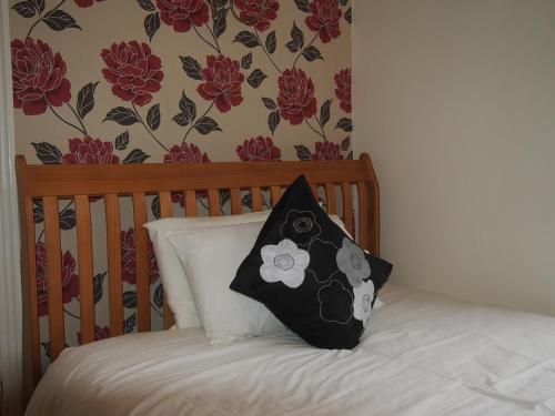 a black and white pillow sitting on top of a bed at Bodhyfryd Guesthouse in Betws-y-coed