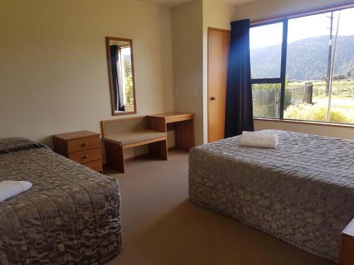 Habitación de hotel con 2 camas y ventana en Mt Cook View Motel, en Fox Glacier