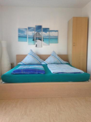 a bed with blue sheets and blue pillows on it at Gästehaus Tante Tienchen 7 Minuten zu Fuss zum Europa Park , plus kostenloses Parkplatzticket Rulantica ,alle unsere Suiten haben einen Balkon in Rust