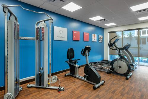 a gym with cardio equipment in a room with blue walls at Comfort Suites Fort Lauderdale Airport & Cruise Port in Dania Beach