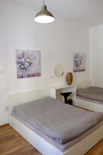 a bedroom with two beds and two paintings on the wall at Lovecroatia Zagreb - 'Pax nest' in Zagreb