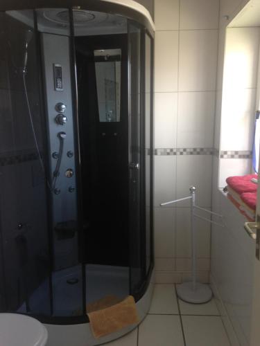 a shower with a glass door in a bathroom at Gästehaus Tante Tienchen 7 Minuten zu Fuss zum Europa Park , plus kostenloses Parkplatzticket Rulantica ,alle unsere Suiten haben einen Balkon in Rust