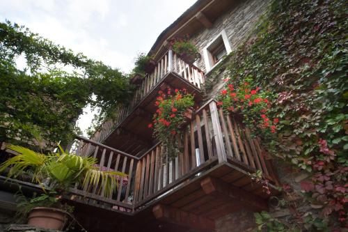 a balcony with red flowers on a building at Agriturismo L'Eco in Morbegno