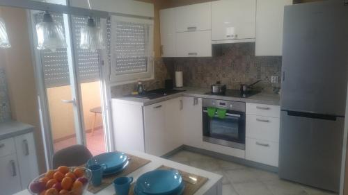 kuchnia z białymi szafkami i niebieskimi naczyniami na stole w obiekcie Apartment Joanna Grau de Gandia w mieście Los Mártires