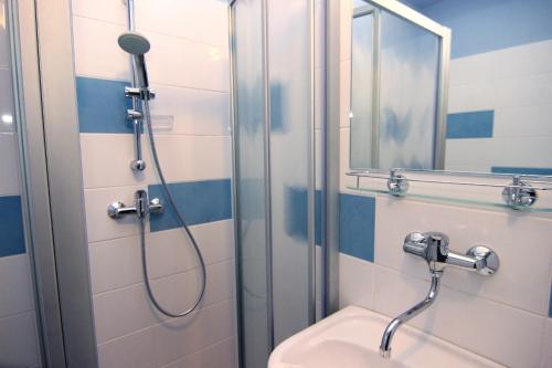 a bathroom with a shower and a toilet and a mirror at Hotel Marttel in Karlovy Vary