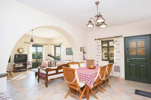 una sala da pranzo con tavolo e sedie di Polykarpos Villa ad Agkidia