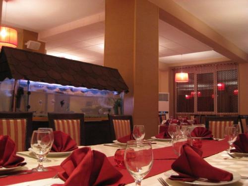een restaurant met een tafel met rode servetten en wijnglazen bij Venec Hotel in Debar