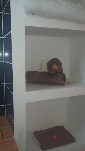 een badkamer met 2 handdoeken op een plank bij Prune de Coton in Deshaies