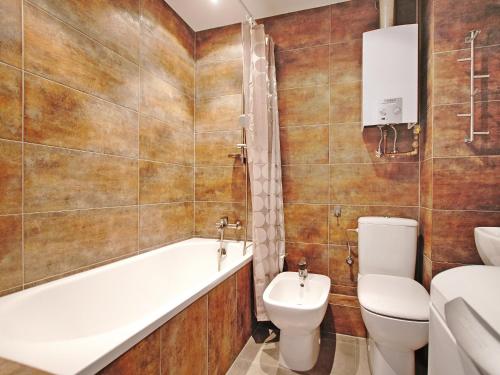 a bathroom with a tub and a toilet and a sink at Apartament Kameralny nad Motławą in Gdańsk