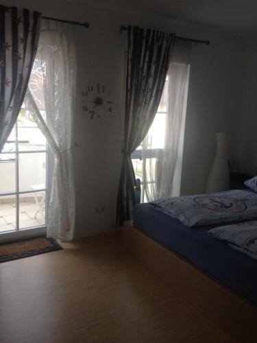 a bedroom with a bed and a window with curtains at Gästehaus Tante Tienchen 7 Minuten zu Fuss zum Europa Park , plus kostenloses Parkplatzticket Rulantica ,alle unsere Suiten haben einen Balkon in Rust