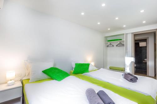 two beds in a bedroom with green and white at Apartments In The City in Rijeka
