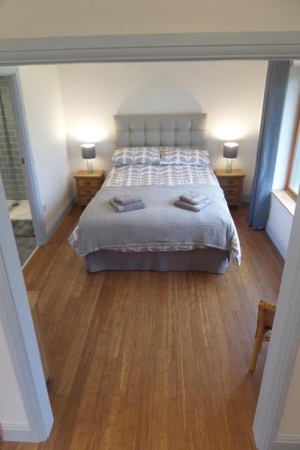 a bedroom with a large bed and two night stands at Curlew Cottage in Eyre