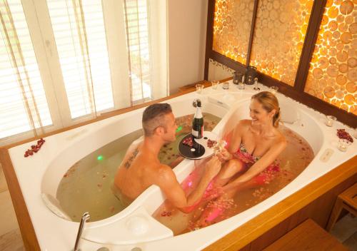 a man and a woman sitting in a bath tub at Wellnesshotel Riedlberg in Drachselsried