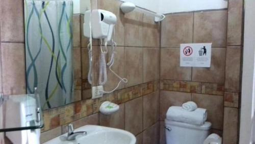 a bathroom with a toilet and a sink and a mirror at Casa Echavarria in San José