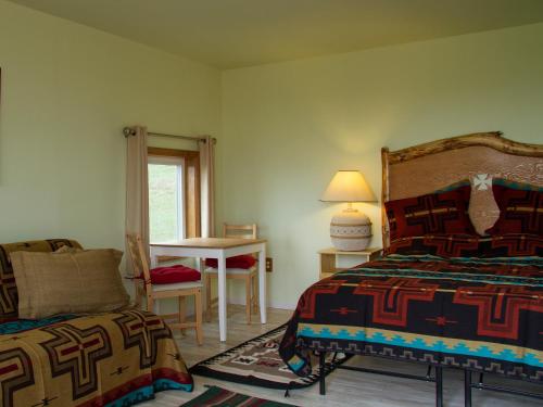 a bedroom with a bed and a table with a chair at Lodgepole Gallery in Browning