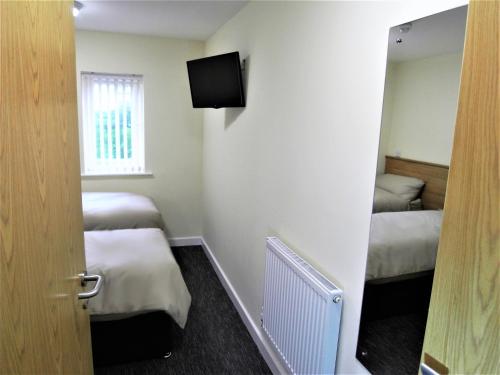Habitación pequeña con 2 camas y ventana en The Stop - Hollies Truckstop Café en Cannock