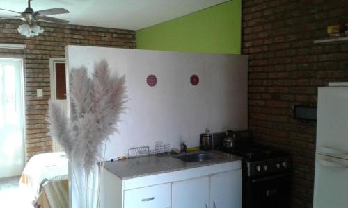 Una cocina con encimera, fregadero y frigorífico. en Casa de Silvia, en Villa Carlos Paz