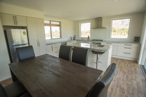 cocina con mesa de madera y suelo de madera en Fox Cottage en Ashwick Flat