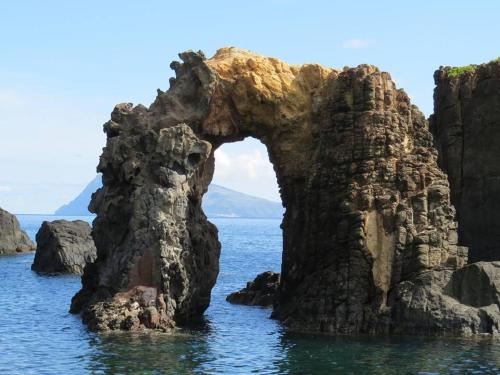 an arch in the rocks in the water at Casas da Quinta in Santa Cruz das Flores