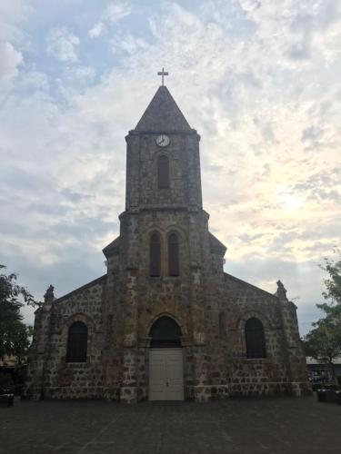 a stone church with a clock tower with a sky at Hotel Don Robert in Puntarenas