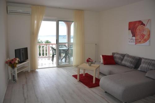 ein Wohnzimmer mit einem Sofa und einem Tisch in der Unterkunft Sea View Apartments Pericic in Sukošan