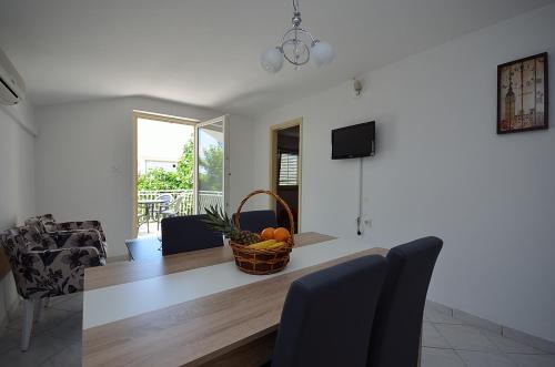 a living room with a table with a basket of fruit at Apartmani Ana in Tribunj