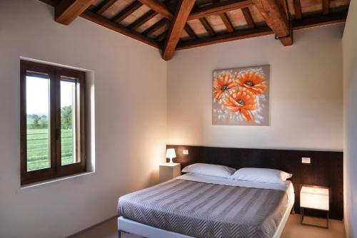 1 dormitorio con 1 cama y una pintura en la pared en Hotel Villaggio Le Stelline, en Montefalco