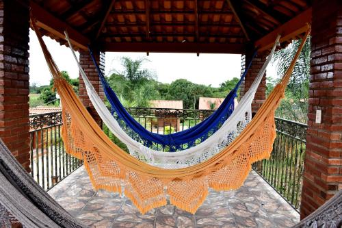 a hammock hanging from a building with a balcony at Pousada Raio de Luz in Pirenópolis