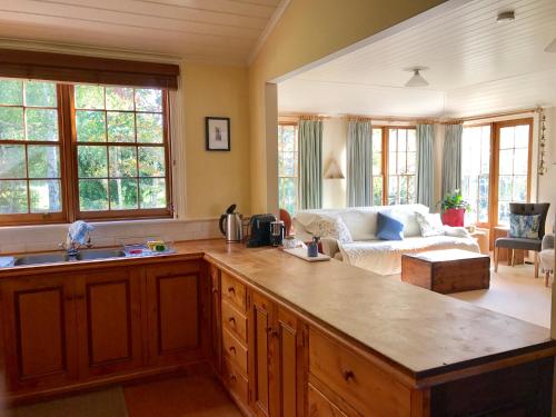 a kitchen with a counter top and a living room at Robin Hoods Well Farm Stay in Sassafras