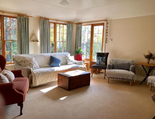 a living room with a couch and a table at Robin Hoods Well Farm Stay in Sassafras