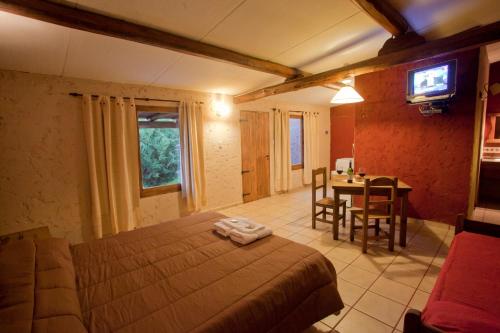 1 dormitorio con cama, mesa y TV en Cabañas del Diamante en San Rafael