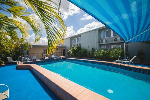 
a swimming pool with a blue canopy on top of it at Hampton Villa Motel in Rockhampton
